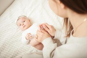 mother plays with newborn baby photo