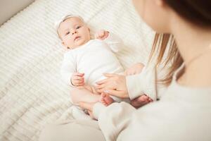 mother plays with newborn baby photo