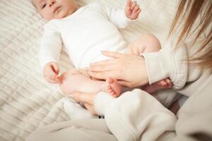 mother plays with newborn baby photo