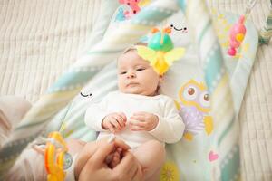 mother plays with newborn baby photo