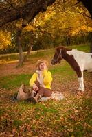 Beautiful picture, autumn nature, woman and horse, concept of love, friendship and care. background. covers face with hand. photo