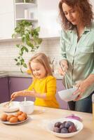 Mother and daughter cook pie in purple kitchen, training and development, interesting game and help. Happy family together. Smile. photo