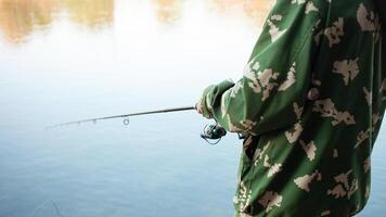 el mayor en banco de río, un hombre con un pescar varilla pesca, hermosa naturaleza, otoño. un antiguo hombre descansa y ama su pasatiempo. activo sano estilo de vida, exterior. cerca arriba foto