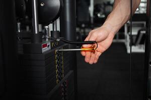 man exposes the weight on the simulator in the gym photo