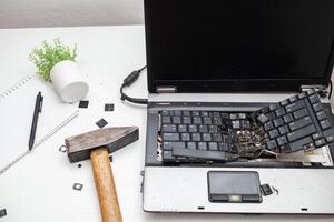 hombre destruido ordenador portátil con un martillo. nervioso trabajar, calesa computadora, errores, lento Internet, no salvado en el juego, impreso texto, colgado. malo antiguo computadora fallido, lo hace no giro en, cuelga. foto