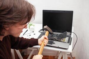 man office worker smashed a laptop, destroyed a computer. Anger, hatred, irritation. Error, brake, malfunction, does not want work. Bad emotions. depression, not preserved. nerves photo