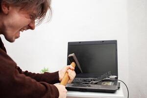 hombre oficina trabajador colocado un computadora portátil, destruido un computadora. enojo, odio, irritación. error, freno, Funcionamiento defectuoso, lo hace no querer trabajar. malo emociones depresión, no Preservado. carcajadas foto