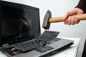 man destroyed laptop with a hammer. Nervous work, buggy computer, errors, slow Internet, not saved in the game, printed text, hung. Bad old computer failed, does not turn on, hangs. keyboard photo