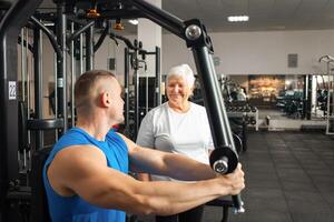 An elderly pensioner plays sports in the gym photo