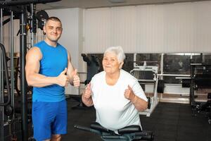 An elderly pensioner plays sports in the gym photo