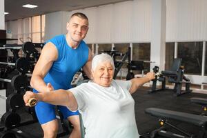 An elderly pensioner plays sports in the gym photo