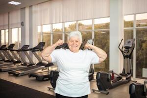 An elderly pensioner plays sports in the gym photo