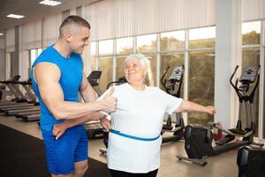 An elderly pensioner plays sports in the gym photo