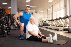 An elderly pensioner plays sports in the gym photo