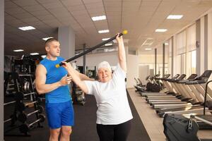 An elderly pensioner plays sports in the gym photo