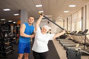 An elderly pensioner plays sports in the gym photo