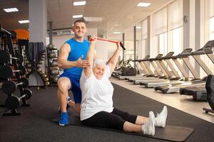 An elderly pensioner plays sports in the gym photo