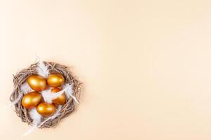 vacío espacio para texto, un bandera de contento Pascua de Resurrección. pintado dorado huevos, plumas. Copiar espacio plano laico parte superior ver nido foto