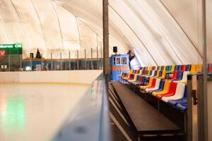 Ice rink multicolored grandstand seats. The indoor rink photo