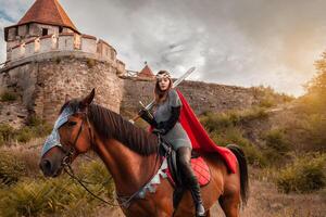 un hermosa niña en el disfraz de el guerrero reina. un mujer en lado de caballo con un espada en su mano. foto