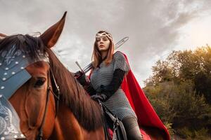 un niña con un espada en lado de caballo en contra el cielo. un hermosa mujer en el disfraz de el guerrero reina. foto
