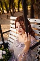 Beautiful bride with bouquet flowers stands on forest background. Rustic style. beautiful bride in delicate dress outdoors. Close up portrait of young bride in park in sunny weather wooded area. photo