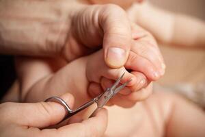 A man cuts her nails child hygiene. men's hands hold nail scissors photo