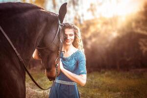 Beautiful girl in a blue dress hugs a horse. Fairytale photography, artistic, magical. photo