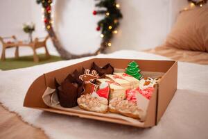 regalo caja para Navidad. entrega de comida a el casa para el nuevo año. pan de jengibre, magdalenas y pasteles un ciervo, un árbol y de santa sombrero. foto