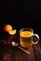 té con naranja, rociado azúcar, rebanado naranja, de madera marrón fondo foto