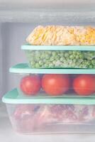 Frozen vegetables and meat in blue plastic containers photo