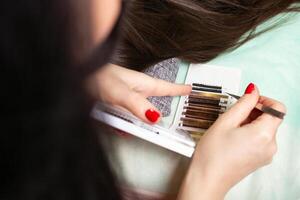 Eyelash removal procedure close up. Beautiful Woman with long lashes in a beauty salon. Eyelash extension. photo