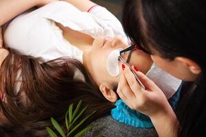 Eyelash removal procedure close up. Beautiful Woman with long lashes in a beauty salon. Eyelash extension. photo