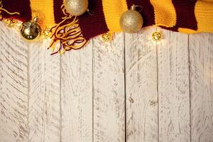 White wooden Christmas background. Empty space for text. Happy New Year. Christmas balls, garland, brown-red scarf. photo