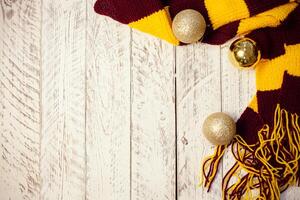 White wooden Christmas background. Empty space for text. Happy New Year. Christmas balls, garland, brown-red scarf. photo