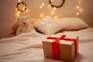 A beautiful gift on the side and a toy bear. A home delivery. Christmas, New Year 2021. photo