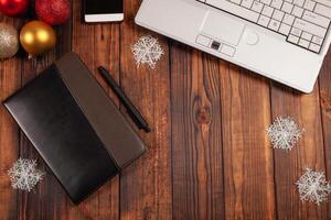 Christmas background for businessmen, leather notebook with black pen, laptop, phone and decorations. photo