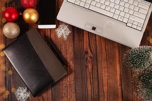 Christmas background for businessmen, leather notebook with black pen, laptop, phone and decorations. photo