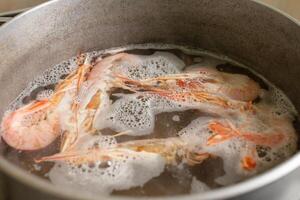 The prawns are boiled in a saucepan on a gas stove. photo