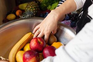 Fruits and vegetables in a large wash bowl. The pastry chef collects the fruit photo