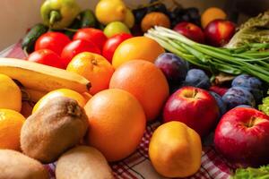 Fruits, vegetables and greens lie on the table, natural light photo