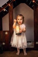 Christmas scenery in the studio, a little girl with a magic flashlight, a candle. Magical New Year, art photography, on Christmas night. photo