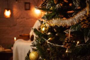 New Year's photo zone in the studio. A chair, a Christmas tree with balls and cones. Yellow garland, lights, candles, lamps, books. Home interior for Christmas.