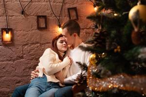 A guy with a girl is celebrating Christmas. A loving couple enjoys each other on New Year's love story. Christmas decorations in the photo studio Posing for models