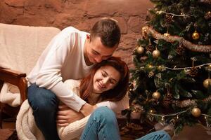 un chico con un niña es celebrando Navidad. un amoroso Pareja disfruta cada otro en nuevo años amor historia. Navidad decoraciones en el foto estudio posando para modelos