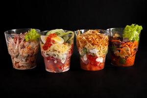 Salads in plastic cups, catering. Home-delivered food. Studio photo