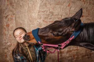 A young girl kisses a horse. A horse kisses his mistress. photo