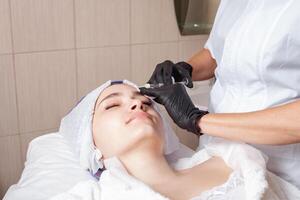 el cosmetólogo realiza el procedimiento de mesoterapia foto