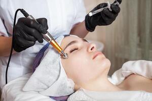 The beautician performs the procedure of electroporation photo