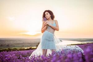 un hermosa joven niña en contra el puesta de sol y un hermosa cielo foto